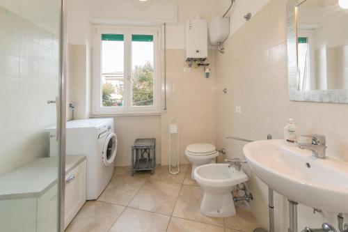 een witte badkamer met een wastafel en een toilet bij Casa dell'elba in Piombino