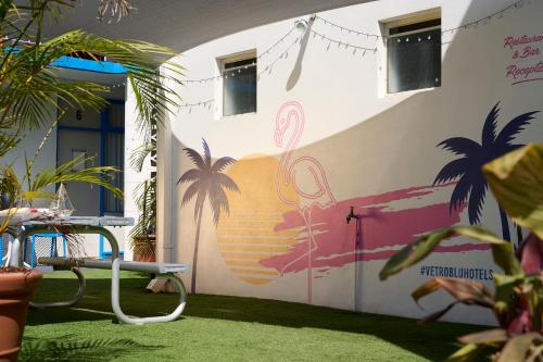 a wall with a mural of a beach and palm trees at Baileys Parkside Motel by VetroBlu in Perth