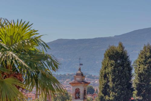 a building with a clock tower in front of a city at Casa Brambilla in Cissano