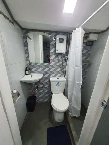 La petite salle de bains est pourvue de toilettes et d'un lavabo. dans l'établissement Cozy Lofts closed to Shopping Malls & MRT Station, à Manille