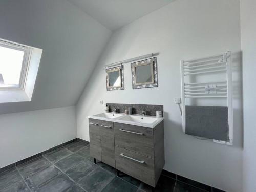 uma casa de banho branca com um lavatório e um espelho em Refuge côté Mer by Melrose em Asnelles
