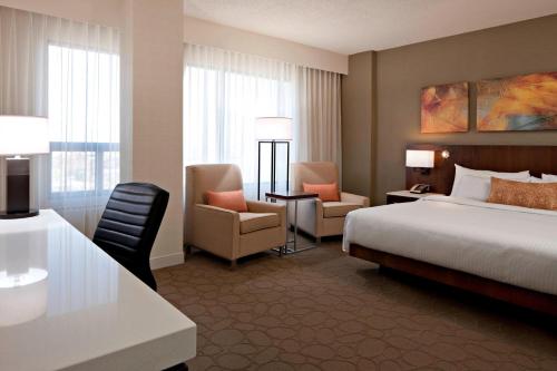 a hotel room with a bed and a desk and chair at Delta Hotels by Marriott Edmonton South Conference Centre in Edmonton