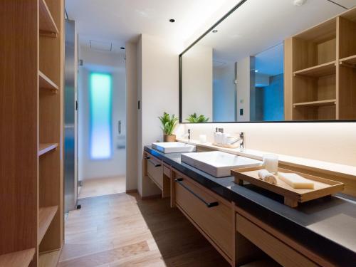 uma casa de banho com 2 lavatórios e um espelho grande em Niseko Kyo em Niseko