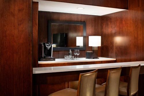 a bar in a hotel room with chairs and a mirror at Delta Hotels by Marriott Edmonton South Conference Centre in Edmonton