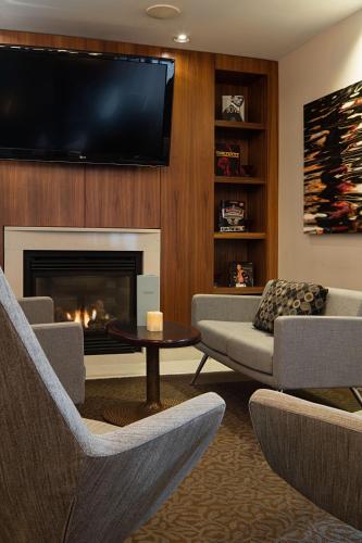a living room with a fireplace and a flat screen tv at Delta Hotels by Marriott Edmonton South Conference Centre in Edmonton