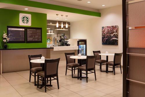 a restaurant with tables and chairs and a counter at Delta Hotels by Marriott Edmonton South Conference Centre in Edmonton