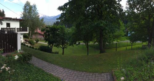 a brick walkway leading to a yard with trees at Karawanken Lodge in Faak am See