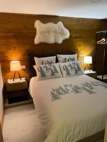 Un dormitorio con una cama blanca con árboles. en gîte à la montagne au calme, 