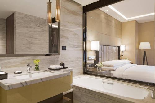 a bathroom with a sink and a large mirror at The Fairway Place, Xi'an - Marriott Executive Apartments in Xi'an