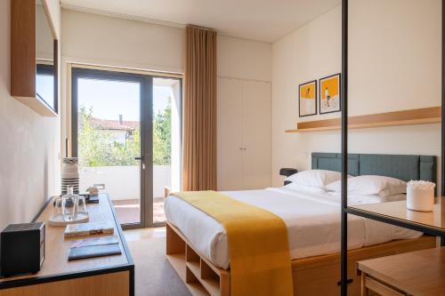 um quarto de hotel com uma cama e uma janela em BFRESH Hotel - Padel, Pool & Fitness - Adults Only no Porto