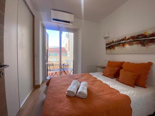 une chambre avec un lit avec deux pantoufles dessus dans l'établissement PACA01, à Nice