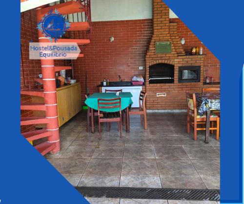 a room with a table and chairs and a kitchen at Hostel&Pousada Equilíbrio in Praia Grande
