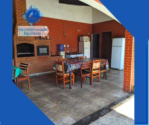 a kitchen and dining room with a table and chairs at Hostel&Pousada Equilíbrio in Praia Grande