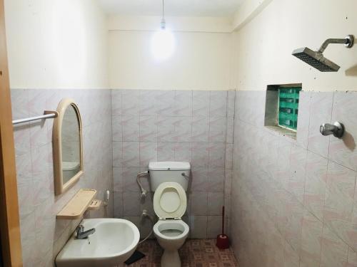 y baño con aseo y lavamanos. en Senani Villa, en Hungama