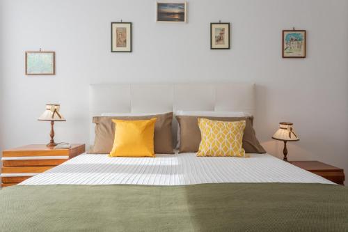 a bedroom with a bed with yellow and green pillows at Saluzzo House by Wonderful Italy in Turin