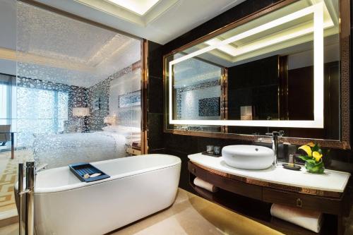 a bathroom with a tub and a large mirror at Changzhou Marriott Hotel in Changzhou