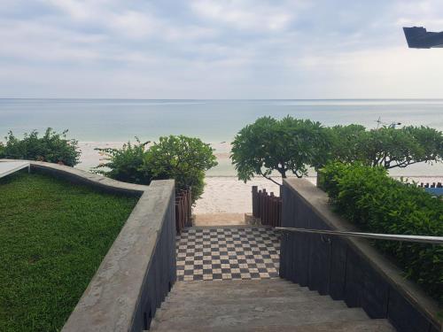 a stairway leading to the beach with the ocean in the background at Baan Sandao Unit 303 in Hua Hin