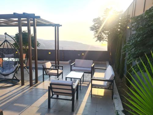 a patio with chairs and tables on a balcony at Zoom Chalets in Amman