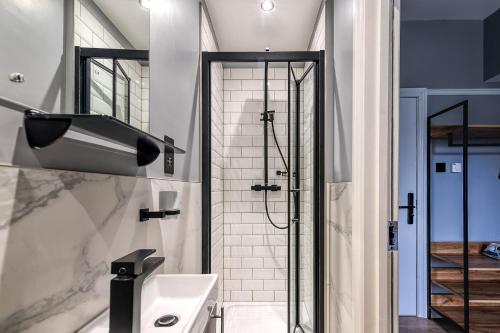 a bathroom with a shower and a sink at Kensington Rooms - Warwick Road in London