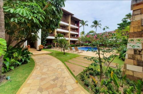a resort with a garden and a swimming pool at Apartamento de charme no Cumbuco in Caucaia