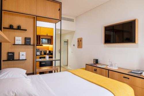 a bedroom with a large bed and a tv at BFRESH Hotel - Padel, Pool & Fitness - Adults Only in Porto