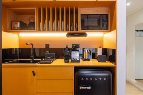 a kitchen with a counter with a sink and a microwave at BFRESH Hotel - Padel, Pool & Fitness - Adults Only in Porto