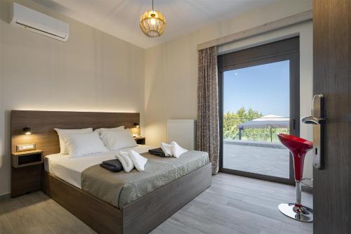 a bedroom with a bed and a large window at Chris apartment with private ecologic pool and kid's playground! in Chania