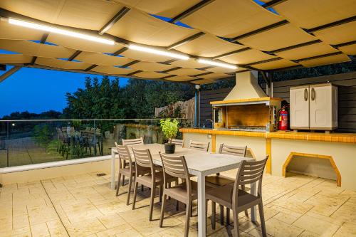 a kitchen with a table and chairs on a patio at Chris apartment with private ecologic pool and kid's playground! in Chania