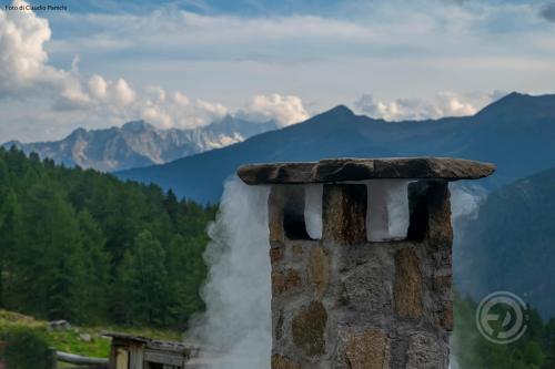 ein Haufen Rauch aus einem Kamin in der Unterkunft Agriturismo Malga Pontevecchio in Cogolo