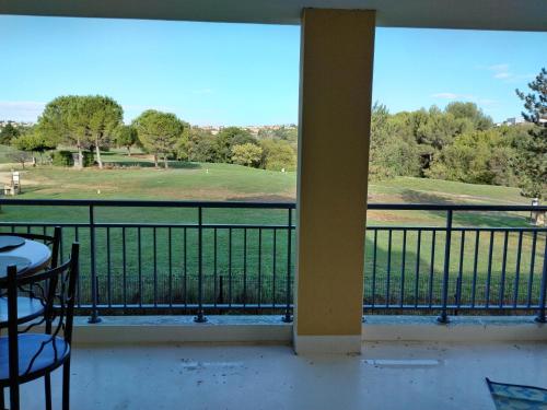 a balcony with a view of a golf course at Suite Deluxe vue sur Golf in Juvignac