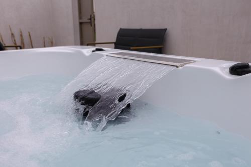 uma banheira com água a sair dela em Un cocon climatisé avec jacuzzi em Marsilly