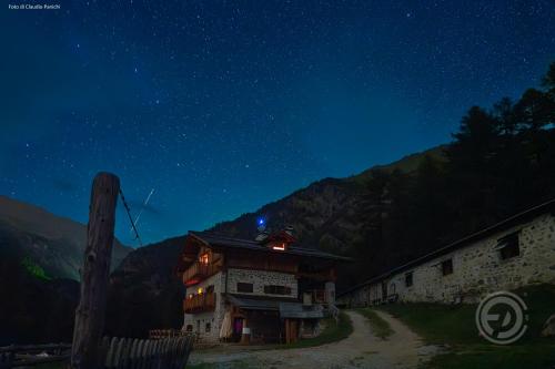ein altes Gebäude in der Nacht mit Sternenhimmel in der Unterkunft Agriturismo Malga Pontevecchio in Cogolo