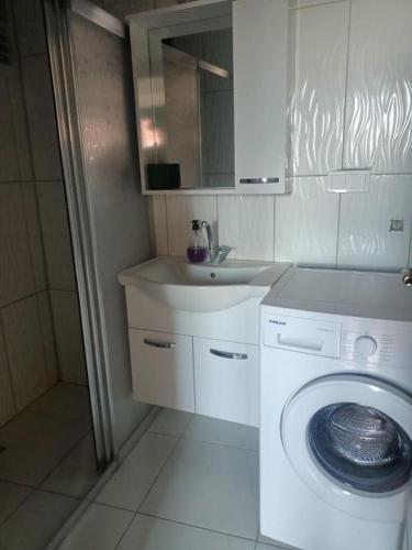 a bathroom with a washing machine and a sink at Old Town Grand Apart Hotel in Antalya