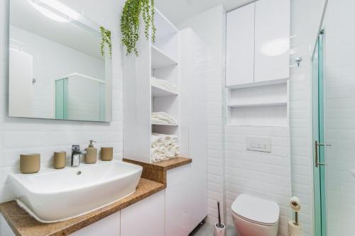 a white bathroom with a sink and a toilet at Apartment Saga With Terrace And Parking - Happy Rentals in Zagreb