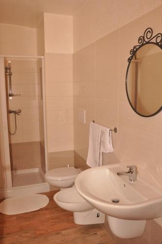 a bathroom with a sink and a toilet and a mirror at B&B Duca Orsini in Gravina in Puglia