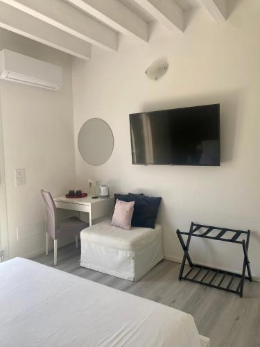 a bedroom with a bed and a desk and a tv at Villa Carlotta in Salionze