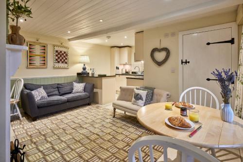 Guinea Cottage في Great Somerford: غرفة معيشة مع طاولة وأريكة