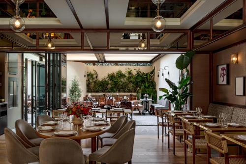 ein Esszimmer mit Tischen und Stühlen sowie ein Restaurant in der Unterkunft Hotel Norman Paris in Paris