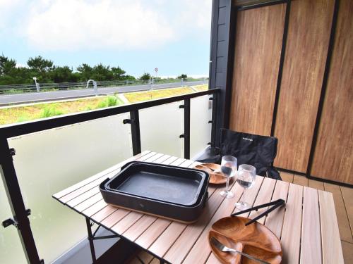 Rakuten STAY MOTEL Kujukurihama Katakai 202 1LDK with BBQ terrace في Kujukuri: طاولة مع صينية فوق شرفة