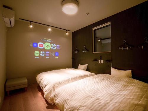 1 dormitorio con 1 cama blanca grande y espejo en Rakuten STAY MOTEL Kujukurihama Katakai 104 2LDK with BBQ terrace Garage concept room, en Kujukuri