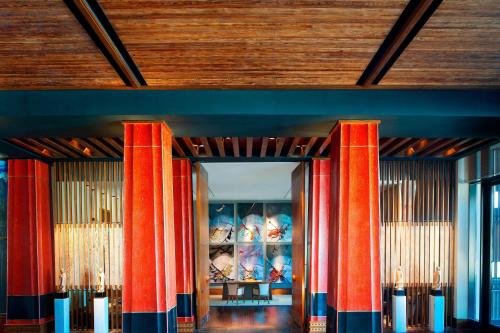 a lobby with red columns and a wooden ceiling at The St. Regis Lhasa Resort in Lhasa