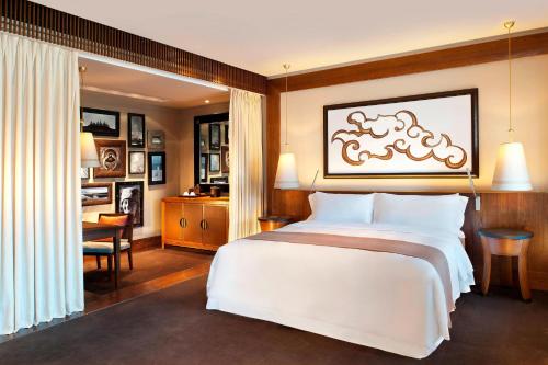 a bedroom with a large white bed and a desk at The St. Regis Lhasa Resort in Lhasa