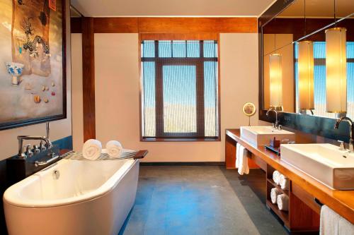 a large bathroom with two sinks and a tub at The St. Regis Lhasa Resort in Lhasa
