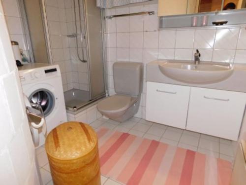 een badkamer met een wastafel en een wasmachine bij Chalet Stadel Sonnet in Bellwald