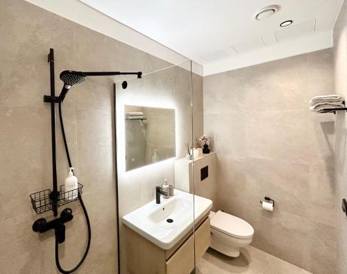 a bathroom with a shower and a toilet and a sink at Esplanaadi Residences in Pärnu