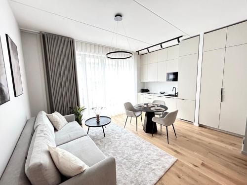 a white living room with a couch and a table at Esplanaadi Residences in Pärnu