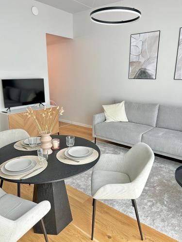 ein Wohnzimmer mit Tisch, Stühlen und Sofa in der Unterkunft Esplanaadi 10 in Pärnu