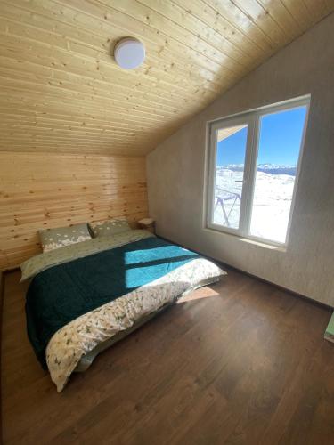 ein Schlafzimmer mit einem Bett in einem Zimmer mit einem Fenster in der Unterkunft სასტუმრო ქორულდი / Hotel Koruldi in Mestia