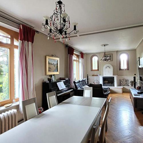 un salon avec une table à manger et un salon avec un canapé dans l'établissement La villa du parc, à Desvres