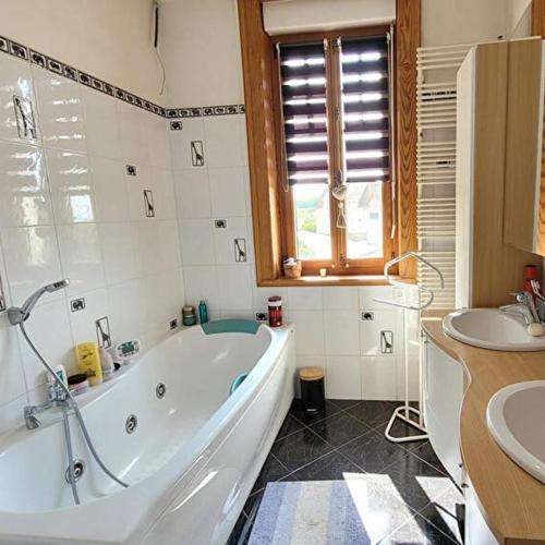 une salle de bain avec une baignoire et un lavabo dans l'établissement La villa du parc, à Desvres